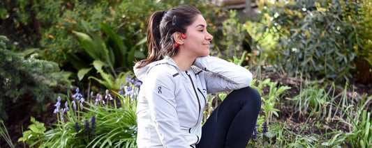 Woman smiling and wearing AfterShokz Aeropex headphones