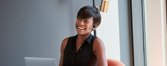 Woman at work wearing AfterShokz OpenComm headset